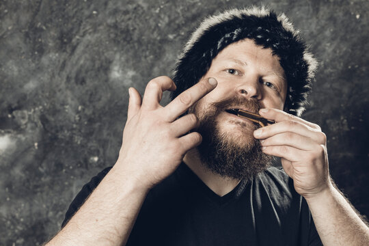 Matured Man In Fur Hat Playing Jews Harp