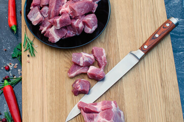 Raw meat diced with a kitchen knife on a cutting board.