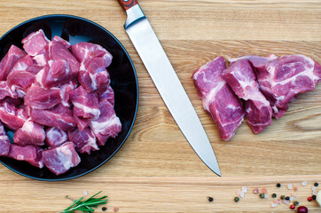 Raw meat diced with a kitchen knife on a cutting board.