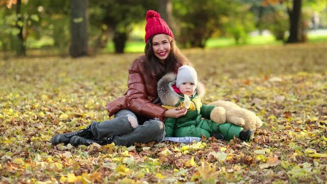 young mom or nanny are playing in the park. mom blows soap bubbles. walk in the autumn on the nature. happy family. close up view. Slow motion video. stock footage