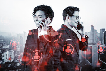 Businessman and businesswoman as a part of corporate team processing conference call to develop social media marketing strategy to achieve business goals. Hologram icons over Kuala Lumpur background.