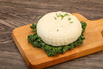 Caucasian suluguni round cheese piece