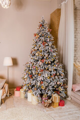 Christmas tree with presents. Holiday decoration.Elegant Christmas tree with white and pink toys in the luxury apartments.Great beautifully decorated tree with pink baubles, ribbons, snowflakes