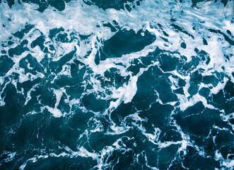 A foam and traces from a past ship on the surface of the Mediterranean Sea in Tunisia. 
Wave trail in the deep part of the sea.