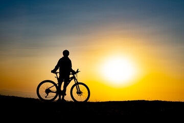 The moment of the cyclist enjoying nature watching the sunrise