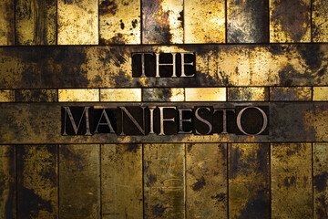 The Manifesto text formed by real authentic typeset letters on vintage textured grunge bronze background