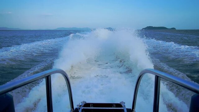 A four-engine speedboat moving at full speed. Traces on the water from powerful speed boat engines