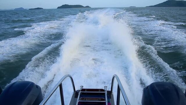 A four-engine speedboat moving at full speed. Traces on the water from powerful speed boat engines