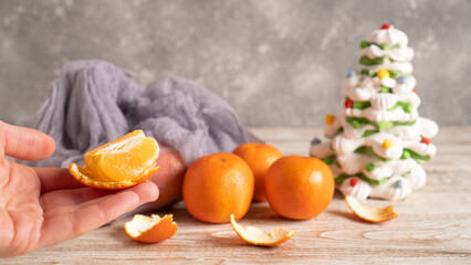 Christmas mood. Hand holding orange. Christmas meringue sweets. Winter holiday background