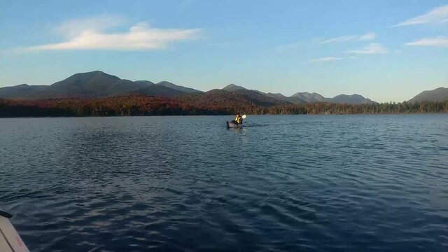 Woman kayaks on a remote Adirondack lake