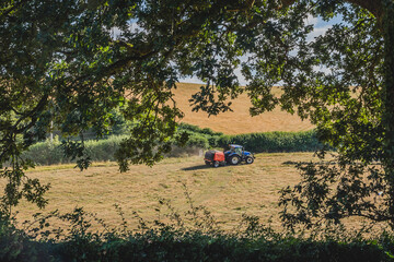 Tractor working on the farm in the Restormel castle surrounding landscape., Uk.