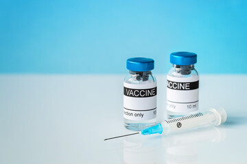 Vials and syringe on light table. Vaccination concept.