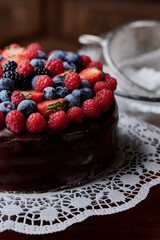 Brown cake decorated with wild berries