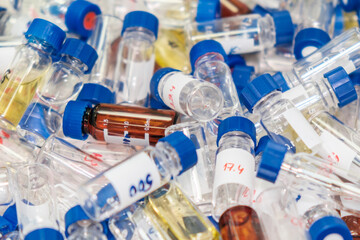 Dirty used chromatographic vials with blue caps. HPLC analysis at analytical chemistry laboratory. Development of pharmaceuticals and vaccines. Chemical waste
