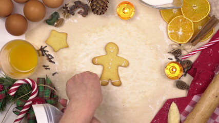 Fototapeta na wymiar Young woman decorates colored glaze festive Christmas cookies in the form of human. View from above.