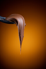 Cream chocolate in spoon on black background	