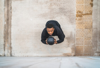 Athletic man doing wall ball exercise.