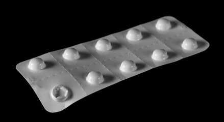  White pills in strip isolated on black background