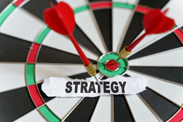 A piece of paper with the text is nailed to the target with a dart - STRATEGY