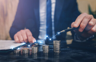 Fototapeta premium Businessman stacking coins with a graph of profit. Business successful growth