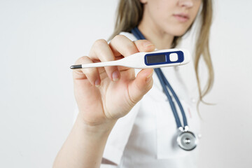 Medicine and health concept. The doctor shows a thermometer into the camera.