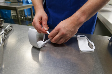 an employee of a surgical department covers the surgical retractor with a white cover