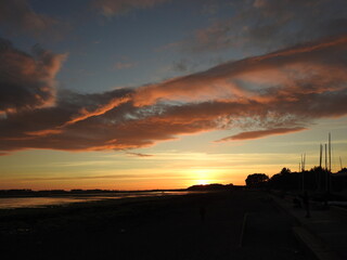 Naklejka na ściany i meble Sunset over the bay with a spreading cloud