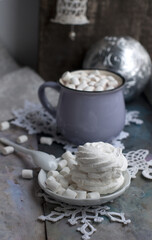 Christmas cup of cocoa with marshmelow on grey background. Cup of New Year's and Christmas cocoa with marshmallows, knitted white snowflakes, bell, sweets and Christmas decorations.