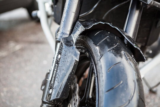 Broken front fender of motorcycle due road collision, close-up view