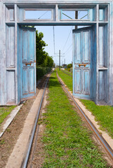 Double doors open to train rails