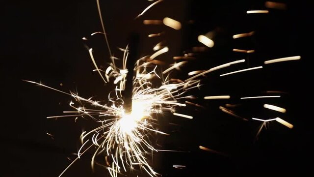 holiday lights and sparks, sparklers on a dark background. flammable. new year holiday