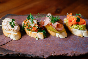 Set of bruschettas on a stone board. Banquet menu snacks.