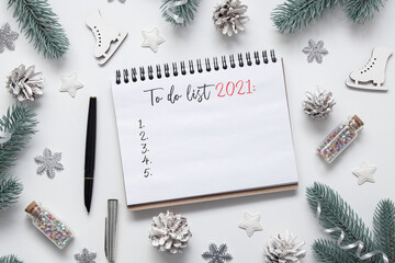 To-do list for 2021 in a spiral notepad on a desk with flat lay winter decor