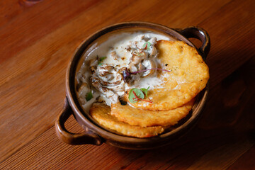Potato pancakes with mushrooms and bacon in sour cream sauce.