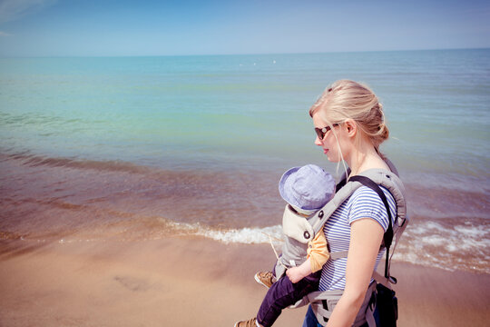 Mother carrying baby son along the beach at the Indiana Dunes National Park - Powered by Adobe