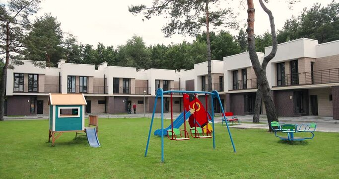 Elite real-estate buildings and playground for kids. Houses at suburbs. Nice semi-detached homes. Place for playing with children at building. Outskirts. Properties.