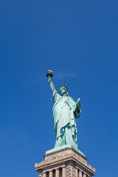 Image of the statue of liberty against a blue sky.