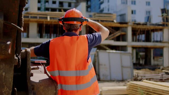Foreman middle-aged at construction site take a look around at the construction and start walking to his workers to analyzing something. Shot on ARRI Alexa Mini