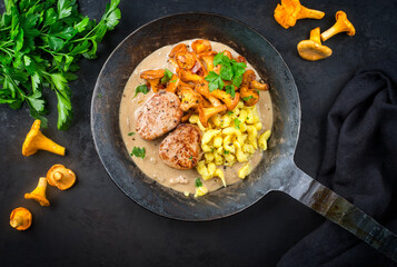 Modern style traditional fried pork filet medaillons in cream sauce with chanterelle mushrooms and...