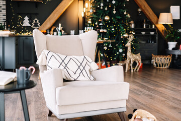 Large white armchair in living room with Christmas tree.