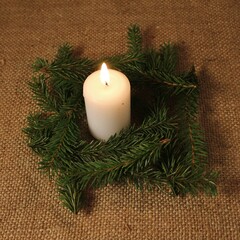 Christmas and New Year decor with white burning candle and spruce branches in eco style.