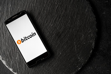 Logo of Bitcoin digital cryptocurrency money on the screen of a smartphone