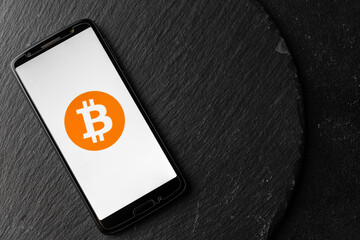 Logo of Bitcoin digital cryptocurrency money on the screen of a smartphone