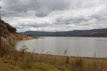 Guatavita tomine lake reflection with grey and white sky landscape.  