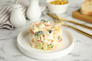 Delicious salad with fresh crab sticks on white marble table