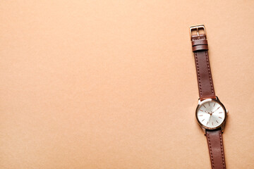 Luxury wrist watch on beige background, top view. Space for text