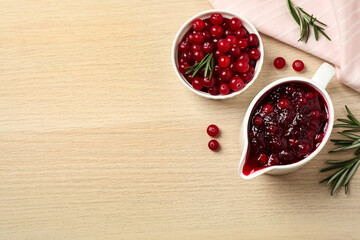 Flat lay composition with cranberry sauce on wooden table, space for text