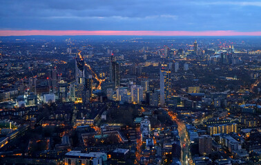 Fototapeta na wymiar Aerial view of south west London, blue hour just after sunset, orange yellow street lights starting to glow