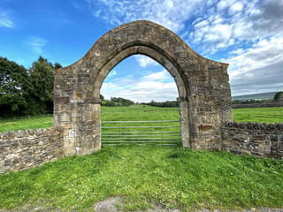 Fototapeta na wymiar Old stone arch, near the ruins of an Abbey, on a hot summers day in, Sawley, Clitheroe, UK