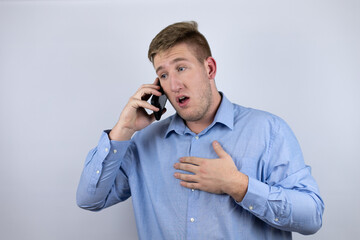 Business young man wearing a casual shirt over white background talking on the phone with a worried expression